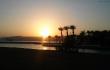 Eilato paplūdimyje grožimės saulėlydžiu palmių ir Raudonosios jūros fone