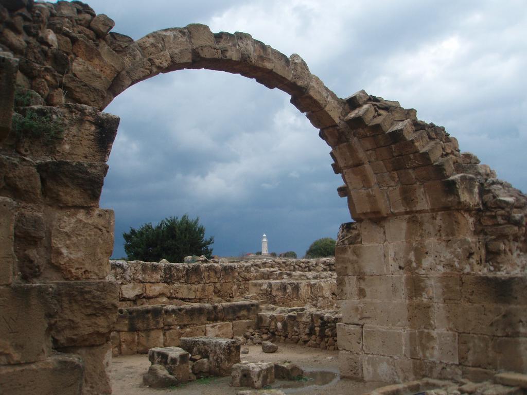 Senovin apgriuvusi arka ir baltas vyturys tolumoje. Kato Paphos, Kipras